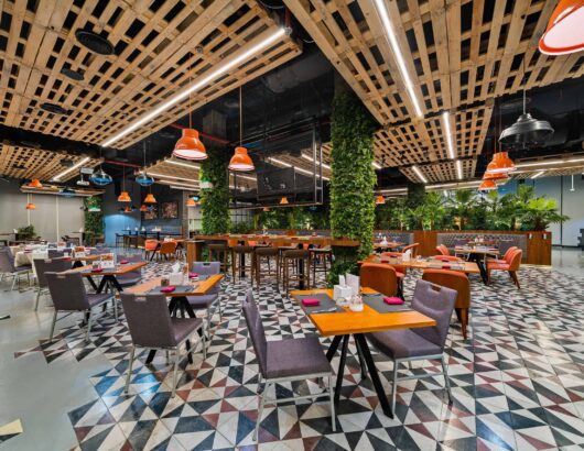 Modern restaurant interior with wooden accents, green walls, and a variety of seating options.