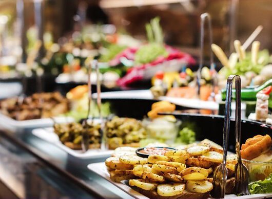 A diverse selection of food on a buffet, offering something for everyone.