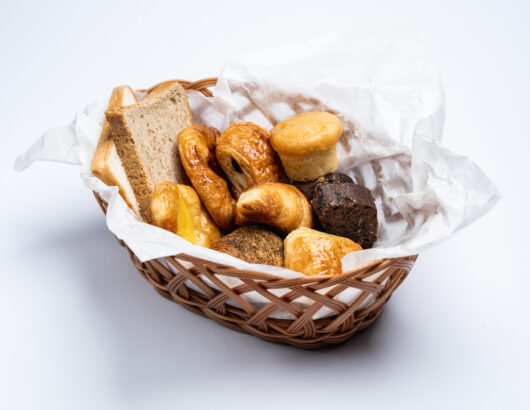 Assortment of baked goods in a wicker basket, perfect for breakfast or brunch.