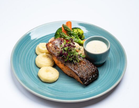 A delicious and healthy meal of grilled salmon with a side of vegetables.